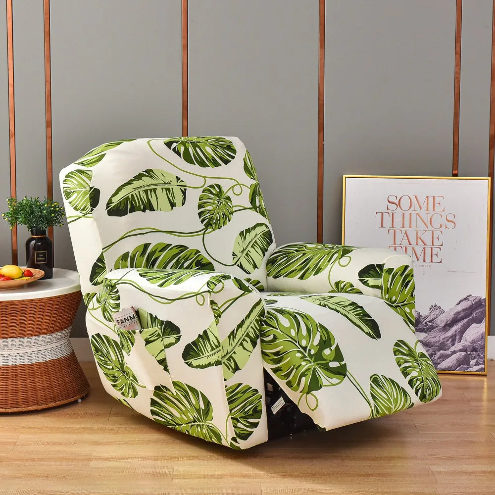 A white slipcover recliner features a vibrant green tropical leaf print on a wooden floor.