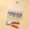 A clear plastic box containing a metal sewing button kit and a pair of pliers on a light background.