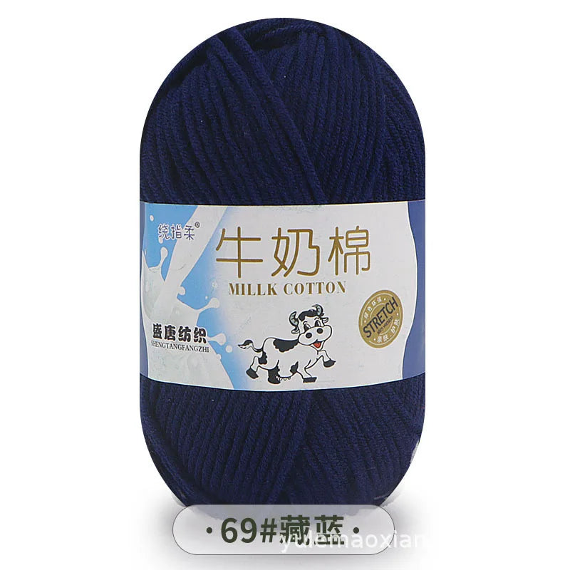 A skein of dark blue milk cotton yarn labeled for knitting.