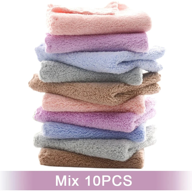A stack of ten luxury coral velvet cleaning face towels in various pastel shades.