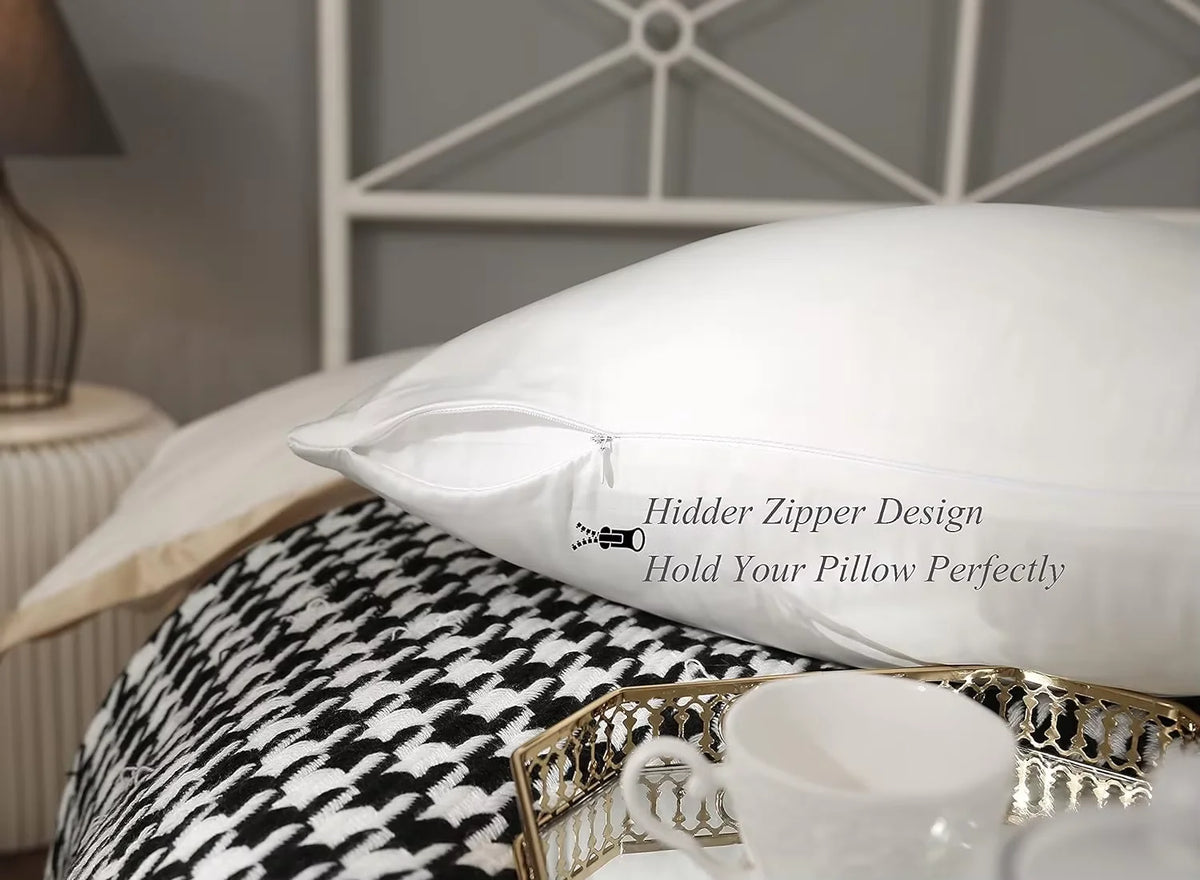 White silk pillowcase with a zipper design resting on a black and white patterned fabric.