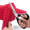 A pair of professional stainless steel pinking shears being used to cut fabric.