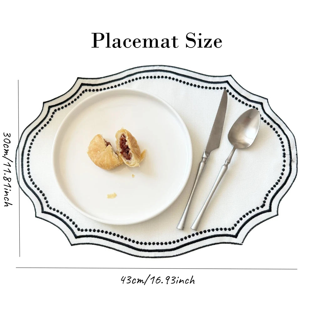 A white placemat is shown with a plate, a knife, and a spoon, demonstrating the size of the placemat.