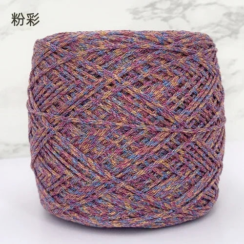A ball of metallic silk crocheting and knitting yarn in shades of purple, pink, and gold.