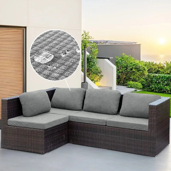 A dark brown wicker outdoor sofa with gray cushions and a circular graphic on the wall.