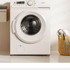 A white washing machine with a round door is shown on a light surface.