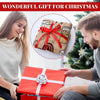 A red gift box with a white ribbon and a white flower is being held by a man, next to a wrapped flannel throw blanket.