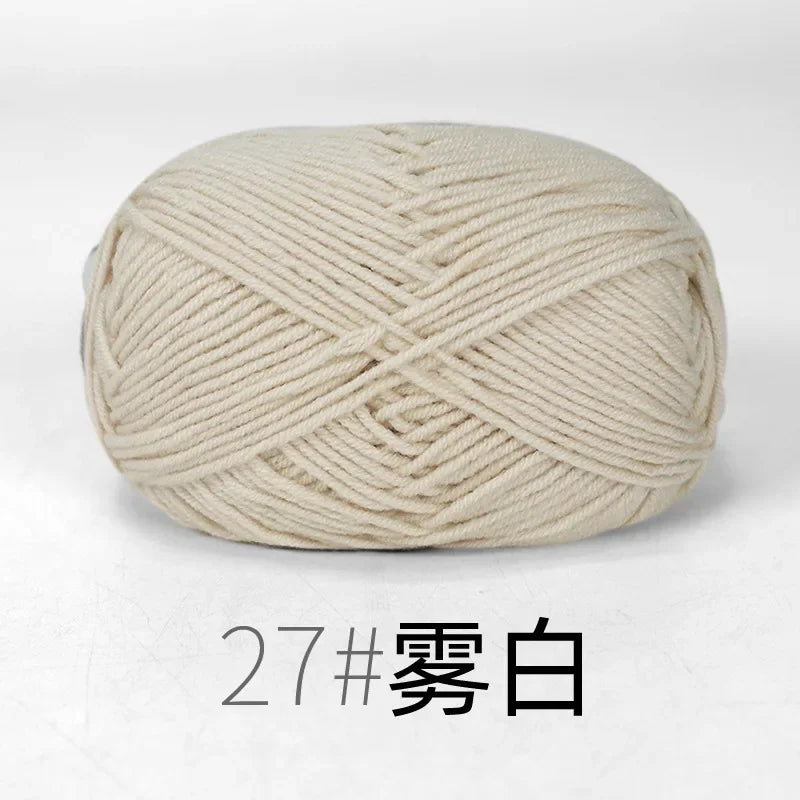 A ball of cream-colored organic cotton 4ply knitting yarn.