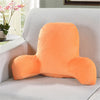 An orange plush lumbar support cushion with arms resting on a light gray sofa.
