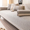 A beige woven sofa cushion cover with light gray accents and decorative piping on a modern sofa.