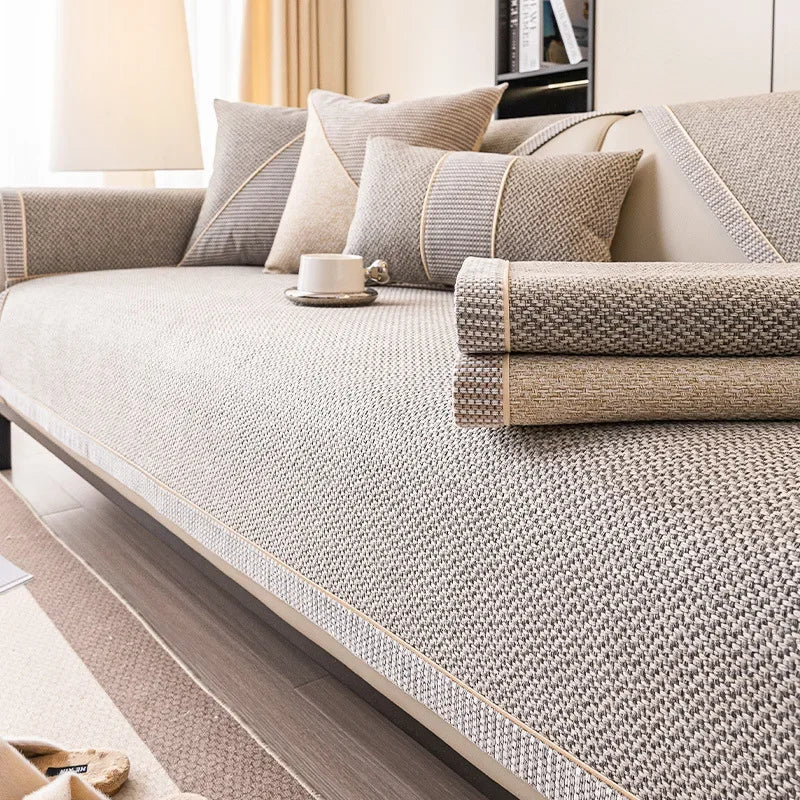 A beige woven sofa cushion cover with light gray accents and decorative piping on a modern sofa.