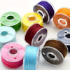 A collection of pre-wound sewing machine bobbins in various colors including green, yellow, purple, orange, and pink.