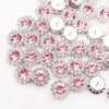 A close-up of silver and pink crystal rhinestone sew-on buttons arranged in a floral pattern.