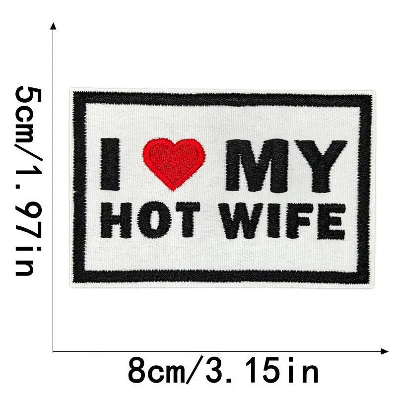 Black embroidered patch with red heart and text I MY HOT WIFE on white fabric
