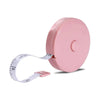 A pink flexible body measuring tape with a white strap and a plastic holder.
