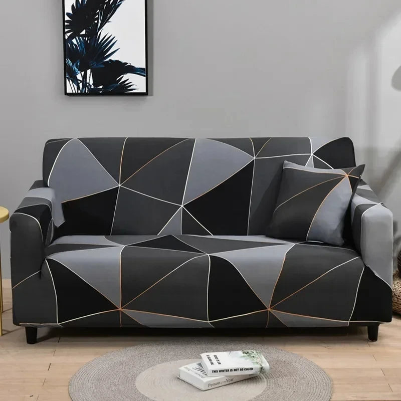 A modern gray and black geometric patterned sofa cover protector displayed on a light wood floor.