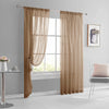A pair of beige sheer curtains hanging in a window frame in a modern living room setting.