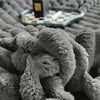 A close-up view of a gray ultra-soft plush winter blanket with a textured, fuzzy surface.