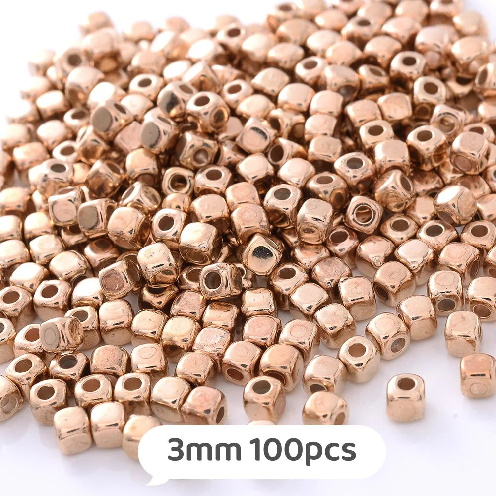A pile of small, round, gold-colored geometric acrylic beads for jewelry making