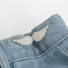 Silver feather button clips attached to a denim fabric