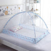 A clear, foldable mosquito net with a light blue floral pattern is set up over a white crib mattress.