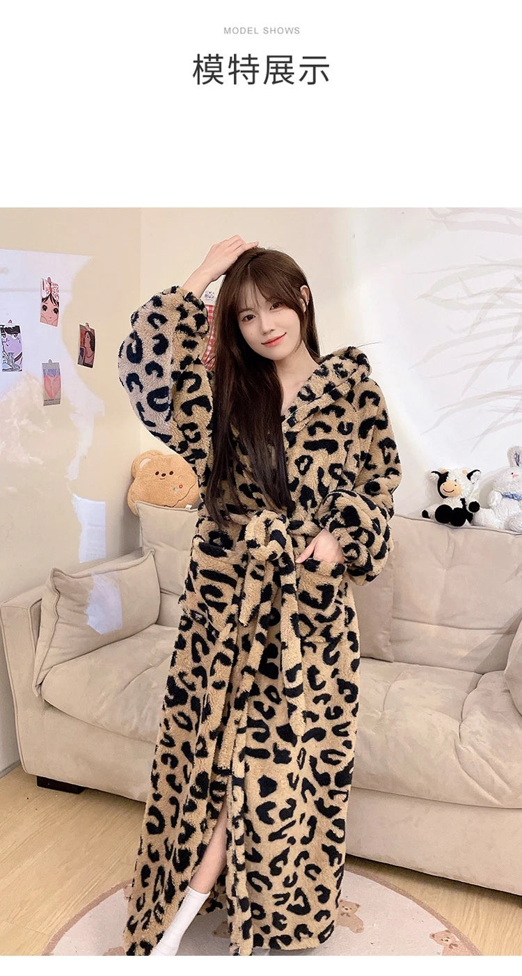 A woman models a long, leopard print flannel kimono robe in brown and black tones indoors.