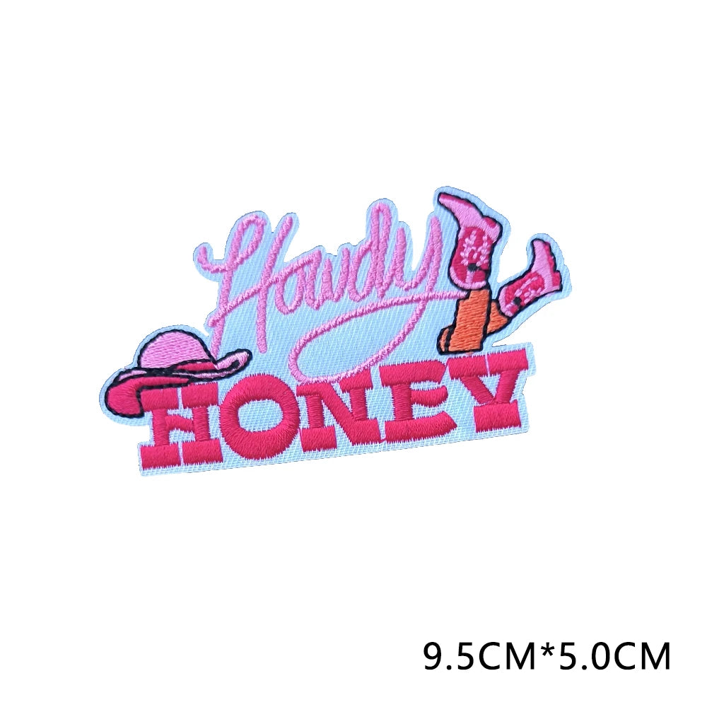 Pink and orange embroidered letter patches spelling out Howdy Honey
