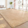 A plush beige bedroom carpet with a fluffy texture is displayed on a wooden floor in a bright room.