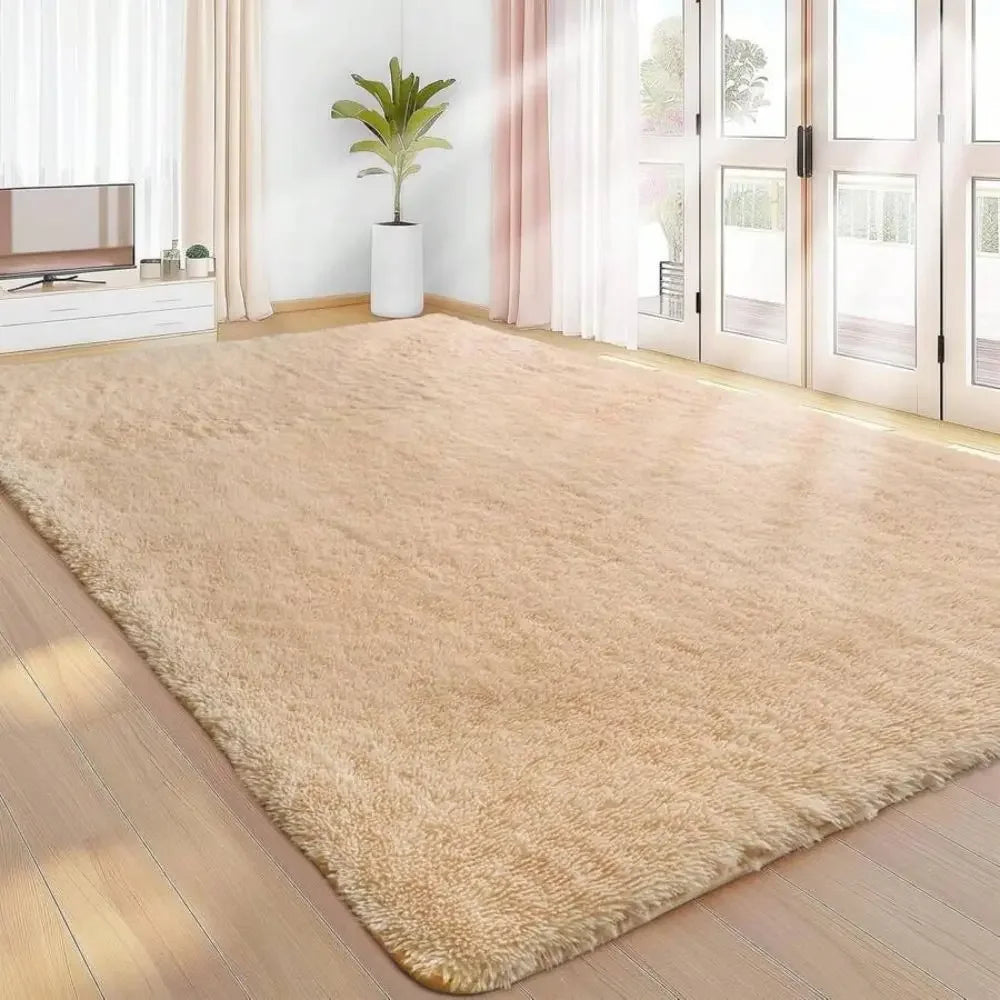 A plush beige bedroom carpet with a fluffy texture is displayed on a wooden floor in a bright room.