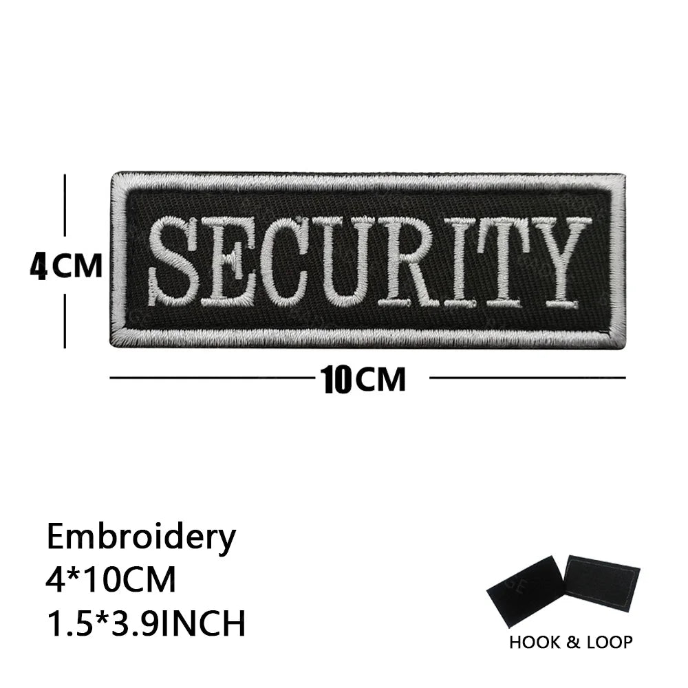Black embroidered security patch measuring 4cm by 10cm with hook and loop backing