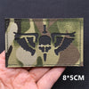 A rectangular tactical patch featuring a camouflage pattern with a silhouette of an eagle on a dark background.