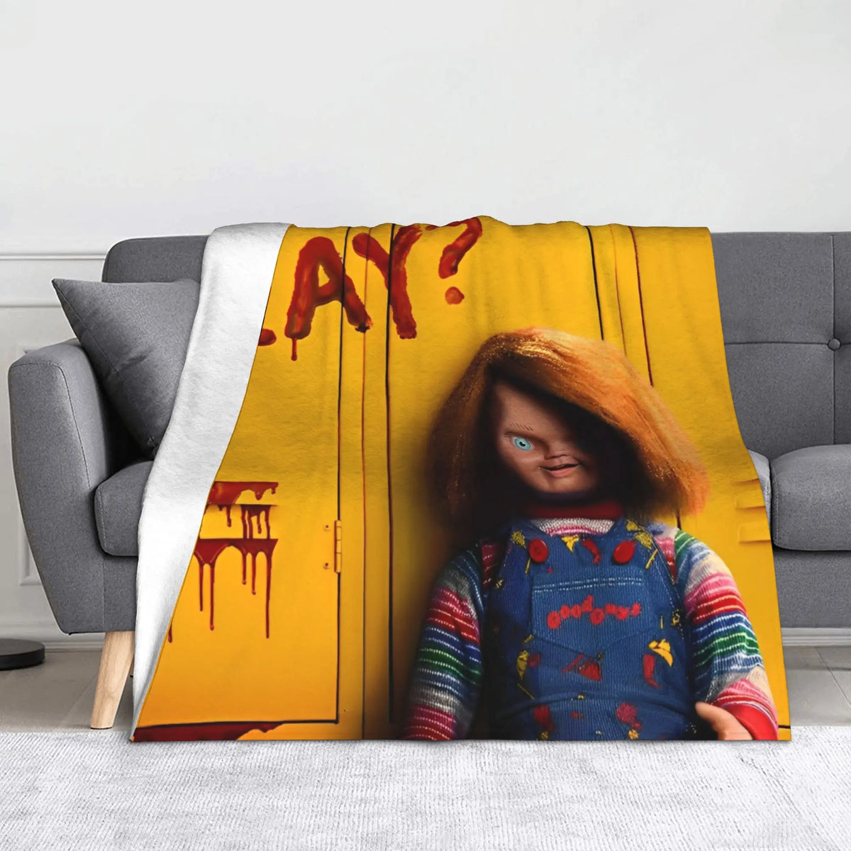 A yellow flannel throw blanket featuring a graphic of Chucky with blood dripping from his mouth.