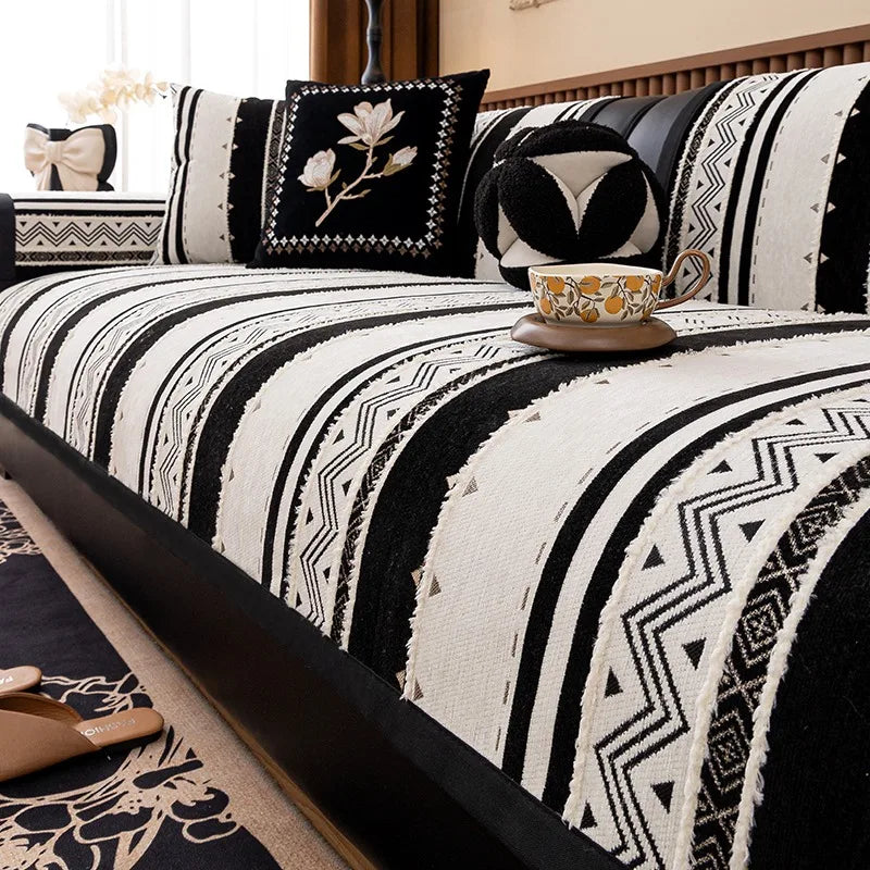 A close-up of a black and white geometric patterned cushion cover on a sofa.