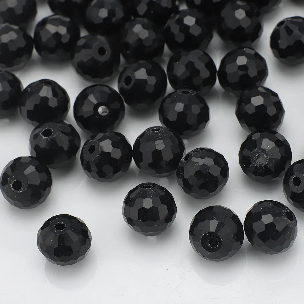 A close-up view of small, shiny black faceted glass beads for jewelry making.