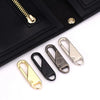 A black leather wallet shows a gold zipper puller and several detachable metal zipper pullers.