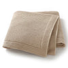 A beige knitted baby swaddle blanket folded and displayed on a white background.
