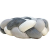 Handmade knotted floor mat for bed decor featuring a woven texture in shades of gray and off-white.