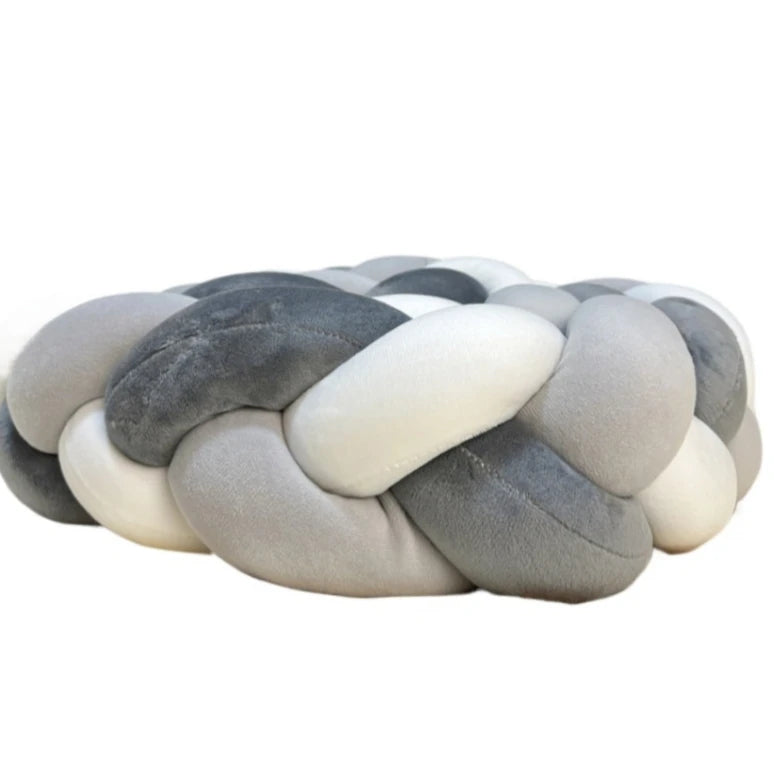 Handmade knotted floor mat for bed decor featuring a woven texture in shades of gray and off-white.