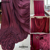 A close-up of rich magenta velvet draping fabric in various folds and styles for decor.