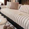 A beige, ribbed plush sofa seat cushion is shown on a black sofa with white and black accents.