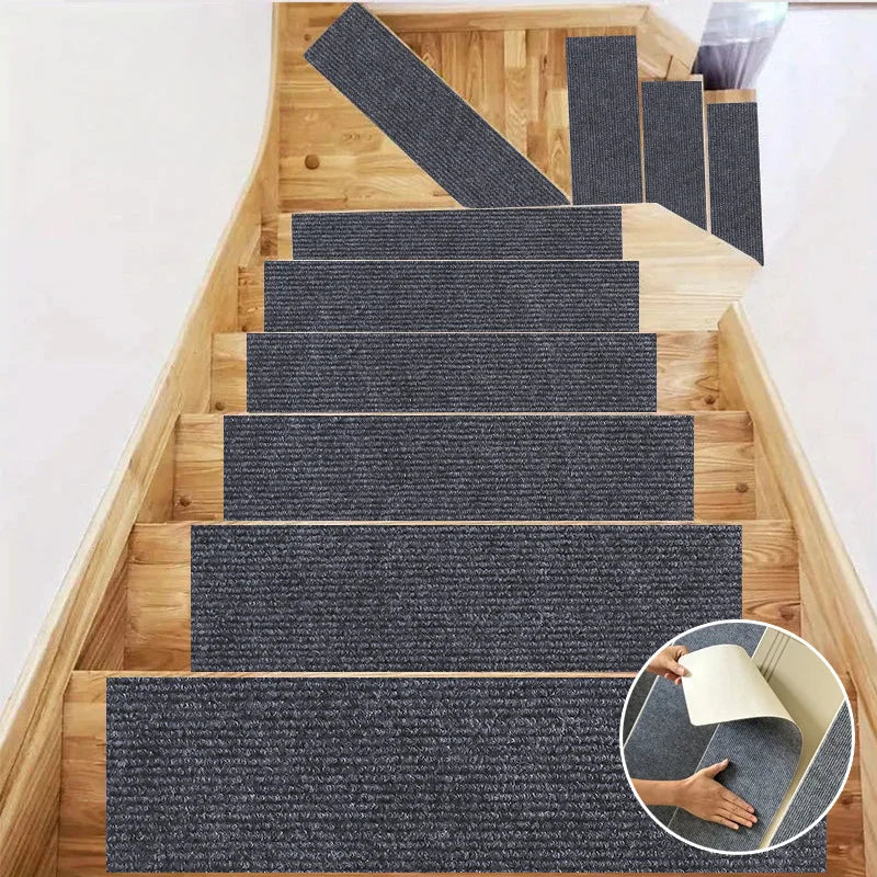 A set of self-adhesive stair and door mats in dark gray and black textured fabric installed on a wooden staircase.
