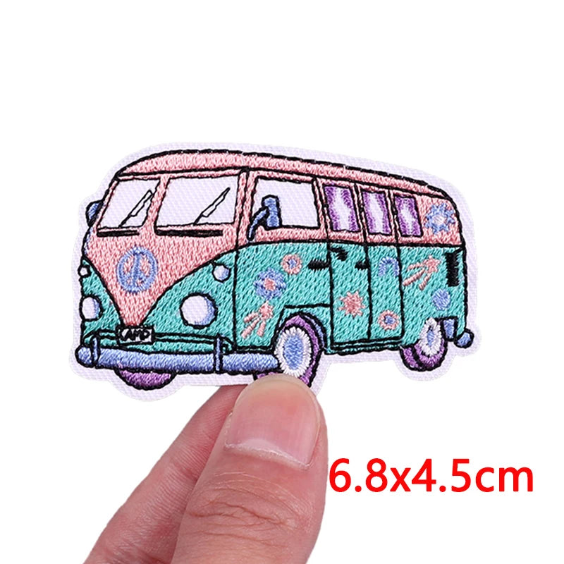 Embroidered iron-on patch of a cartoon bus featuring pink and teal colors.