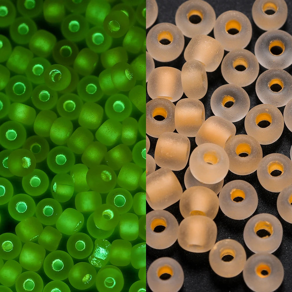 A close-up view of a 600-pack of 3mm glow-in-the-dark glass seed beads in bright green and translucent amber colors.