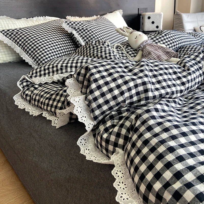 A plaid duvet cover and pillowcase set featuring black and white checkered fabric on a gray bed.