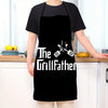A person wearing a black kitchen chef apron with the text The GrillFather and crossed grilling tools printed on it.
