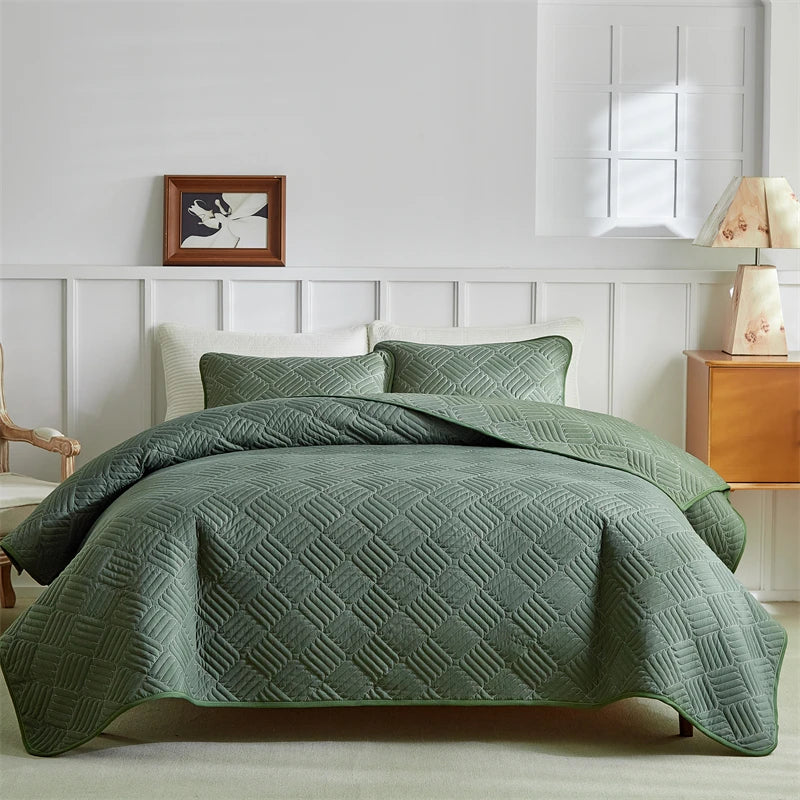 A light green quilted duvet and pillow set on a bed with white paneled walls.