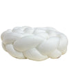 A white handmade knotted floor mat used for bed decor.