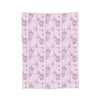 A pink coral fleece cat plush throw blanket featuring a repeating pattern of purple and green cat shapes.