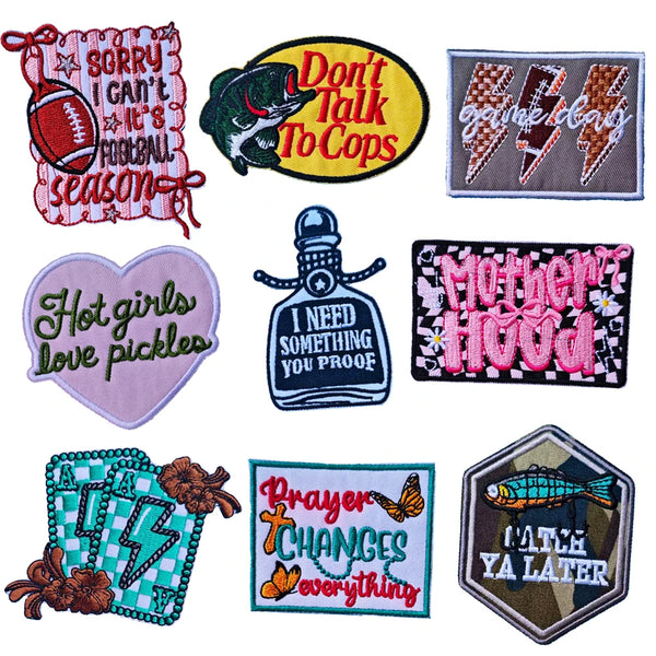 A collection of iron-on embroidered letter patches featuring various sayings and designs.