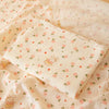 A soft double-layer cotton baby swaddle blanket with a pink floral pattern is displayed on a light fabric background.